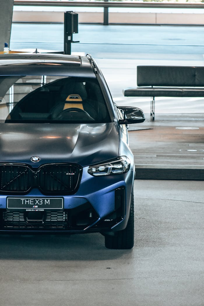 Parked BMW X3 M luxury SUV displayed in a modern Munich showroom, highlighting sleek design.
